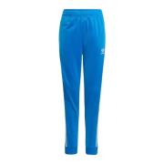 Adidas Originals Ljusblåa träningsbyxor med ikoniska ränder Blue, Unis...